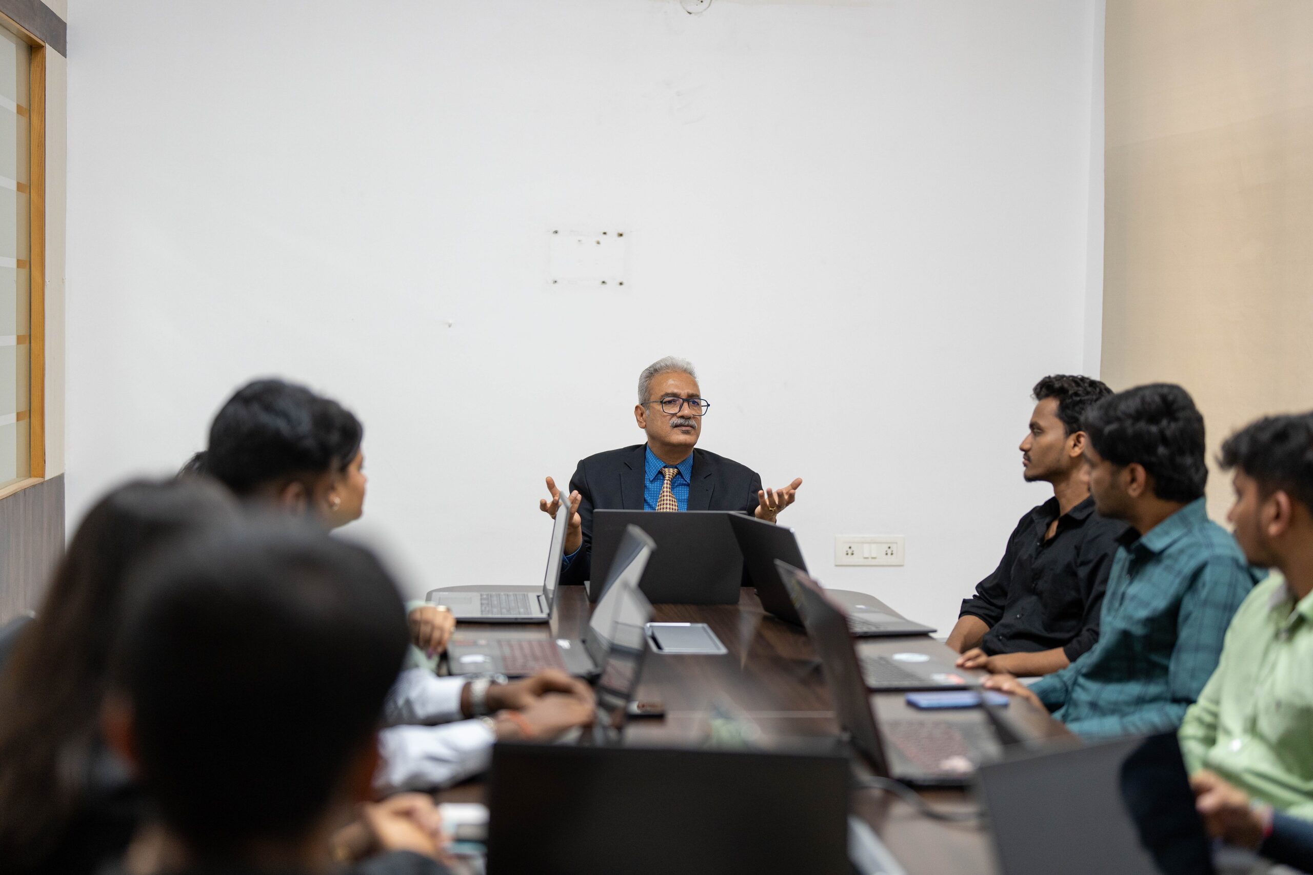 Faculty member guiding a small group of RCMB students around a discussion table