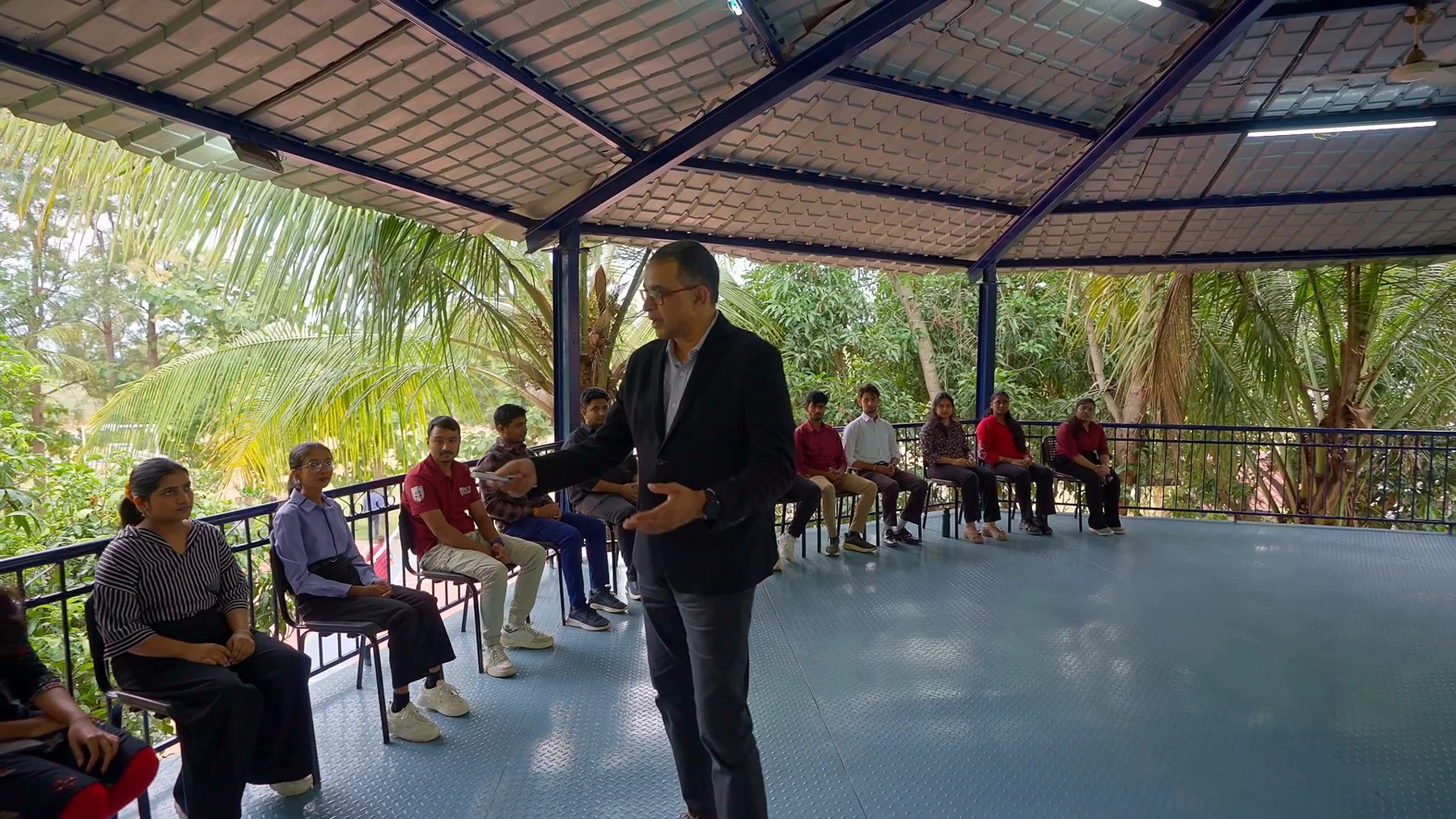 Faculty and students in a wide open-air pavilion session at RCMB